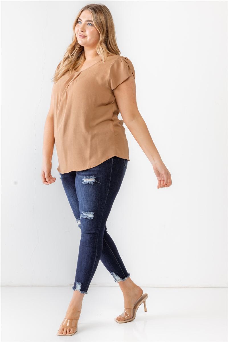 Plus size woman wearing a khaki textured short sleeve blouse with jeans and heels, stylish casual outfit.