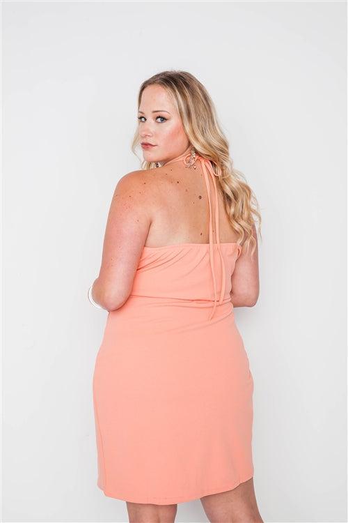 Woman wearing a coral plus size bodycon mini dress with lace details and self-tie cami straps, showing the back view.