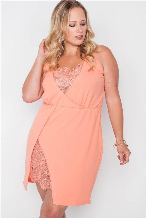 Plus size coral bodycon mini dress with lace detail, surplice neckline, cami straps, and side slit, showcasing elegant and chic style.