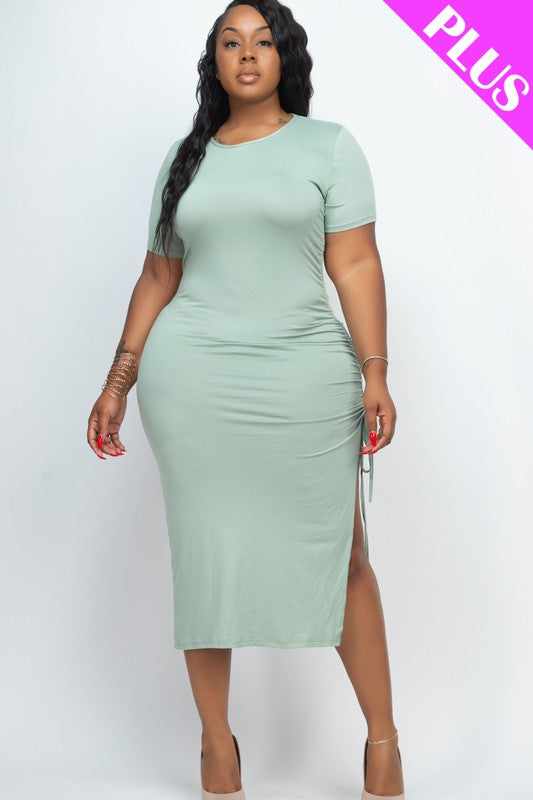 Plus size green midi dress with adjustable ruched side, short sleeves, and side slit, worn by model in 1XL size.
