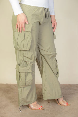 Plus size drawstring ruched parachute pants with flap pockets in khaki, made from lightweight non-stretch woven nylon fabric.
