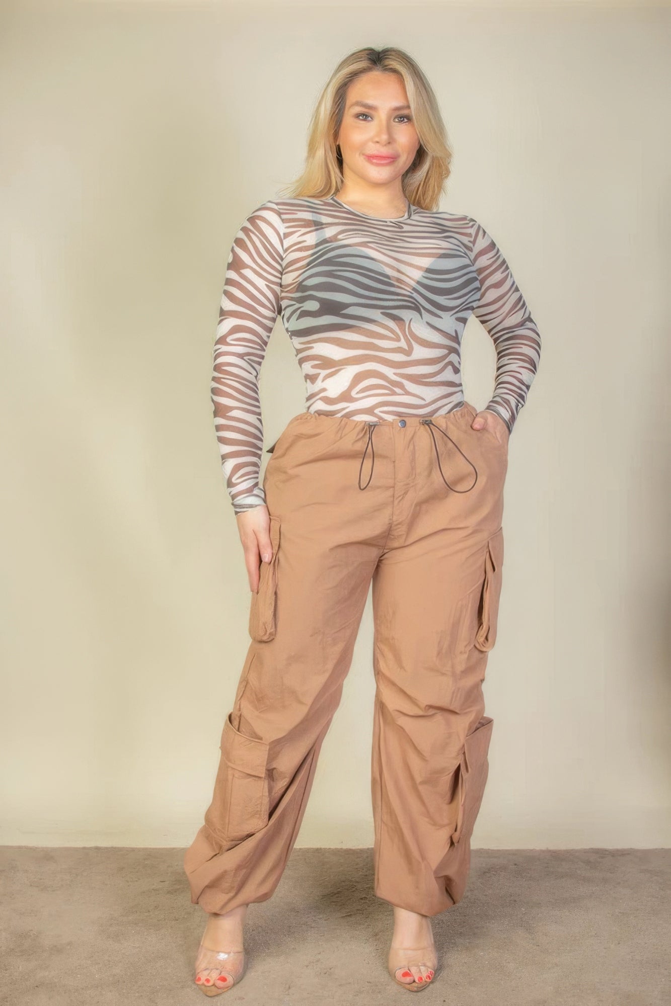 Plus Size Flap Pockets Drawstring Ruched Parachute Pants in brown, modeled with a zebra print top, showcasing a stylish and versatile look.