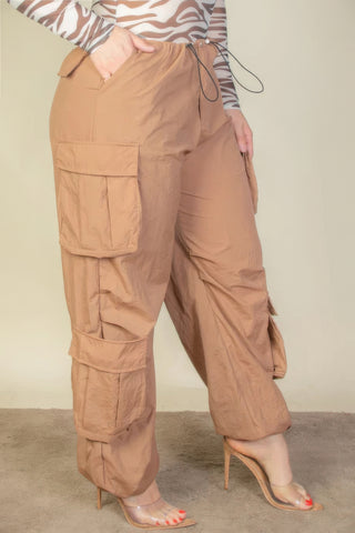 Plus size flap pockets drawstring ruched parachute pants in tan nylon, showcasing stylish design and versatility.