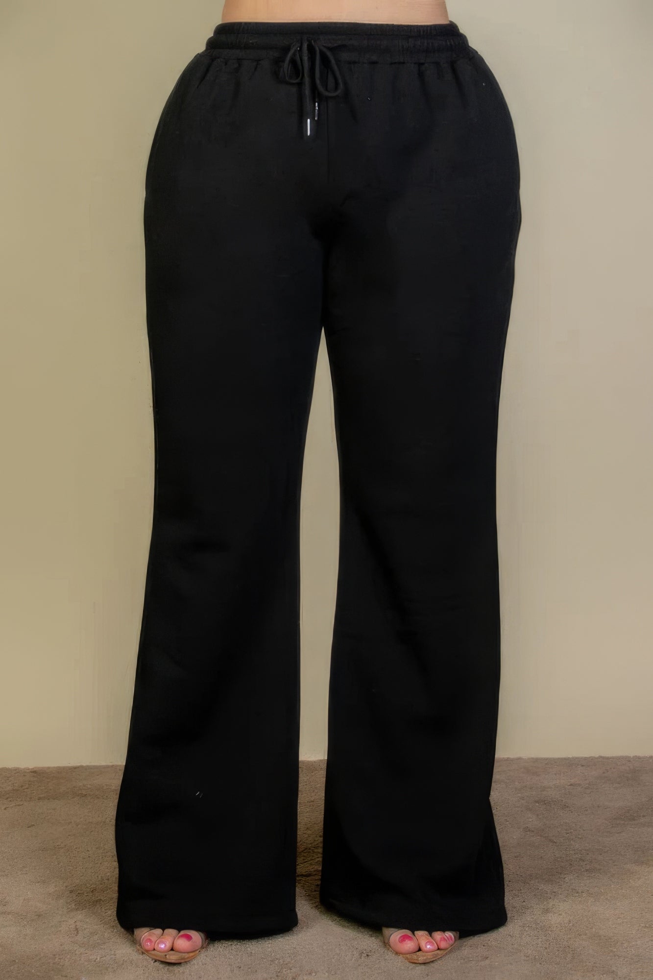 Black plus size drawstring waist sweatpants with slant pockets and bootcut silhouette, perfect for casual wear.