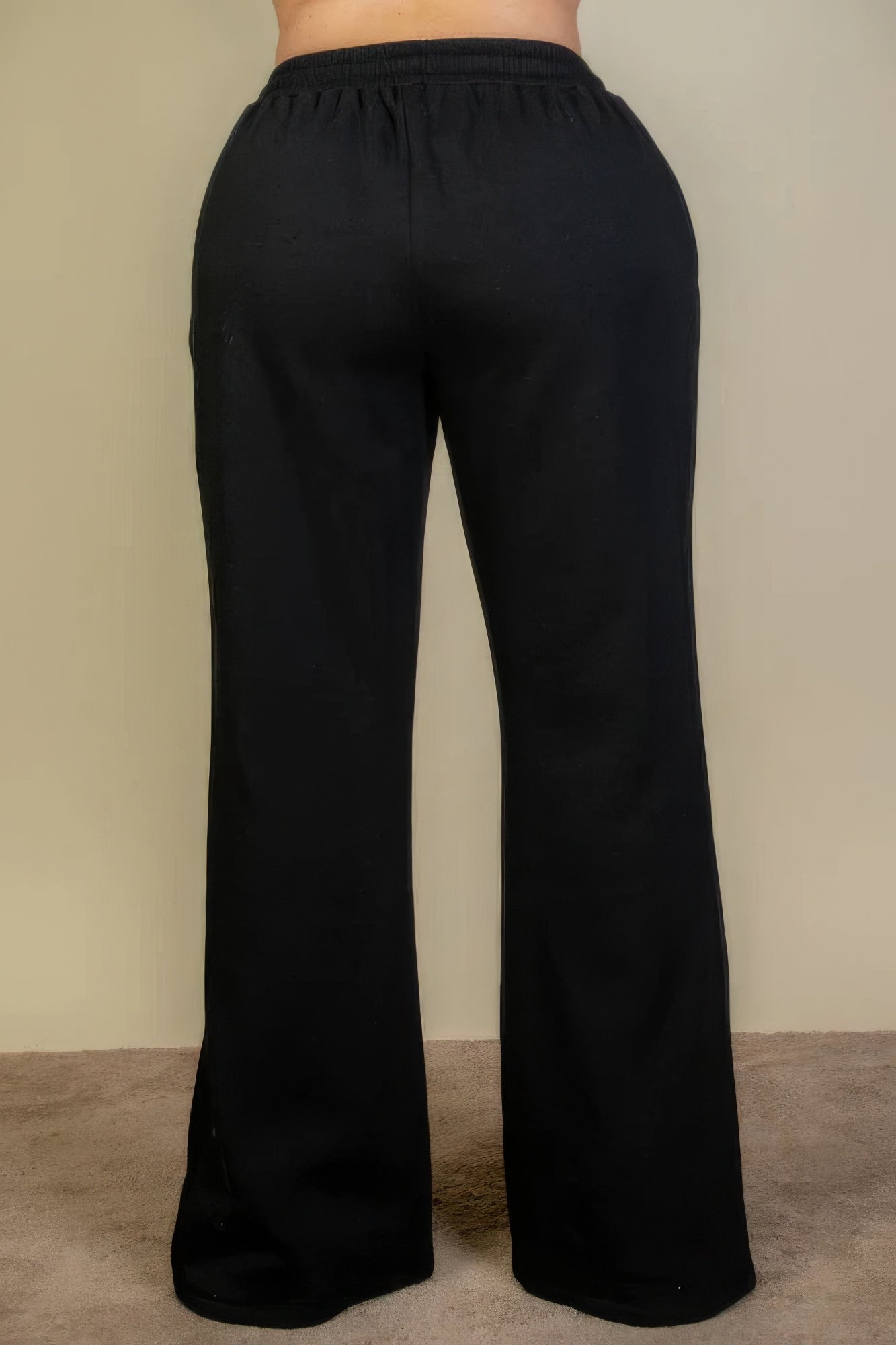 Plus size bootcut sweatpants with drawstring waist in black, featuring slant pockets. Comfortable and stylish for versatile wear.