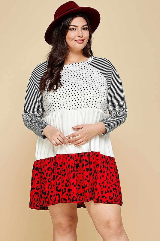 Plus size model wearing a polka dot and animal print swing dress with striped sleeves and a red hat.