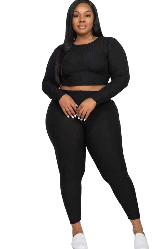 Plus size model in black ribbed two-piece set with crop top and leggings, showcasing casual and activewear style.