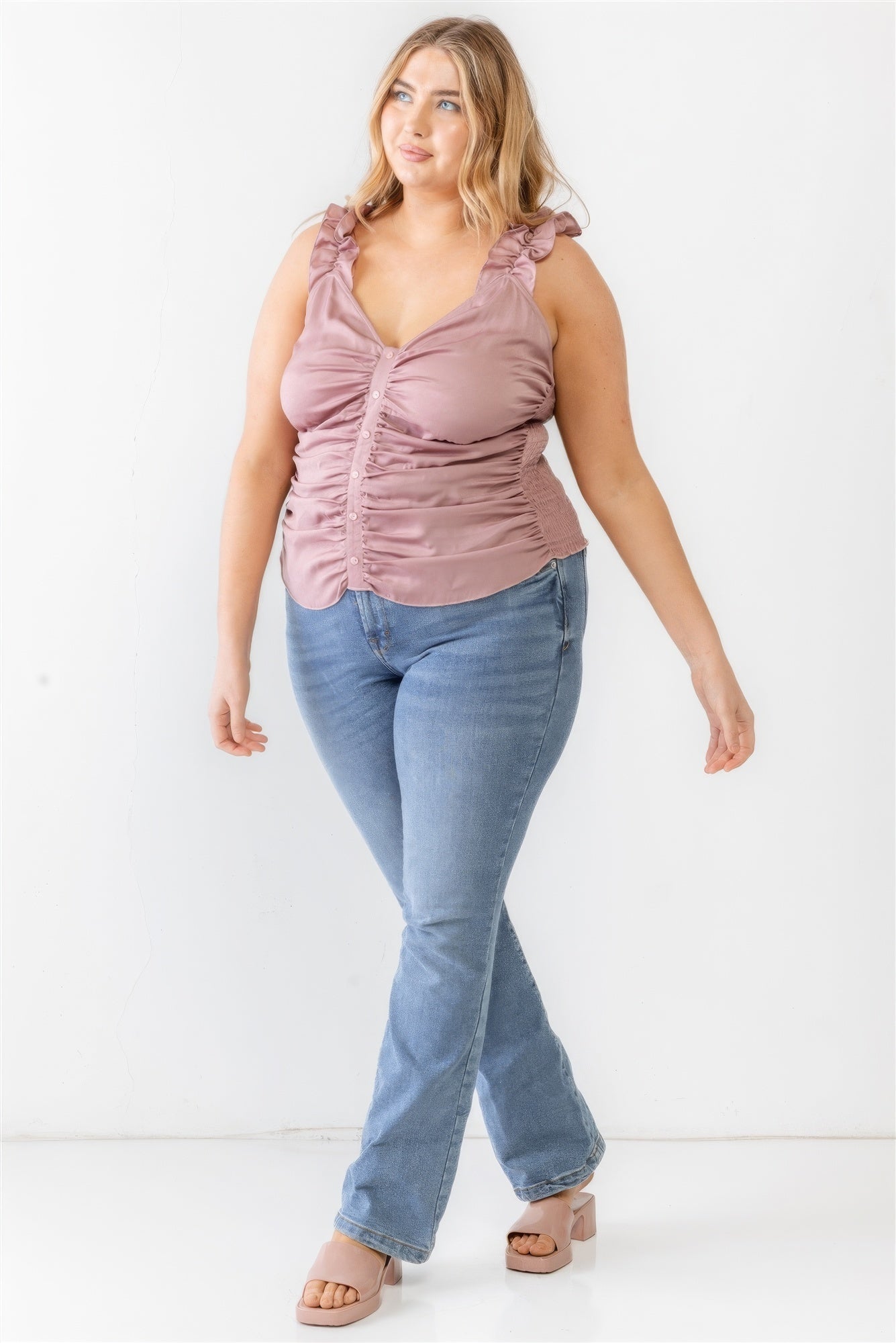 Plus-size woman wearing mauve ruffle strap tank top with ruched button-up front, paired with jeans for a stylish look.