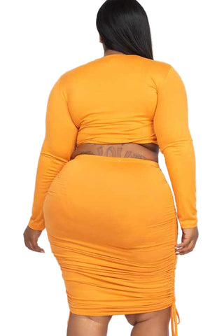 Plus size two-piece skirt set in orange with ruched side crop top and drawstring skirt, soft high stretch material, back view.