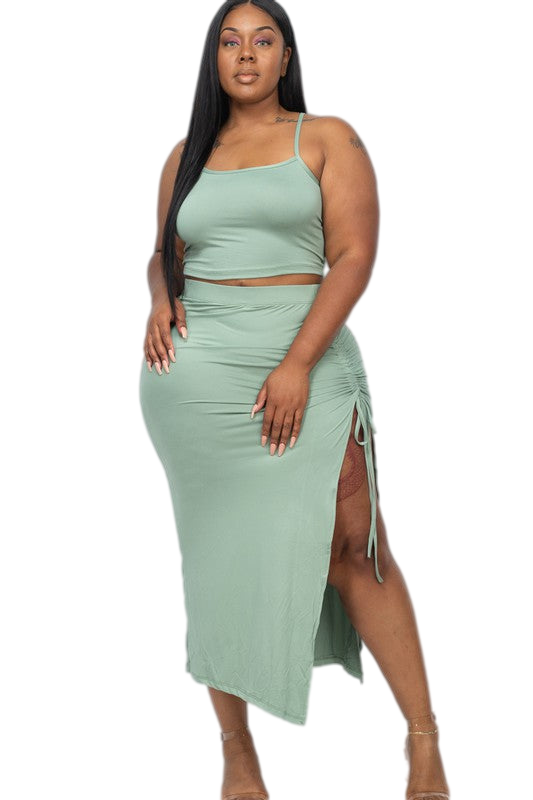 Plus size two-piece skirt set with spaghetti straps and ruched side detail in green, featuring a side slit.