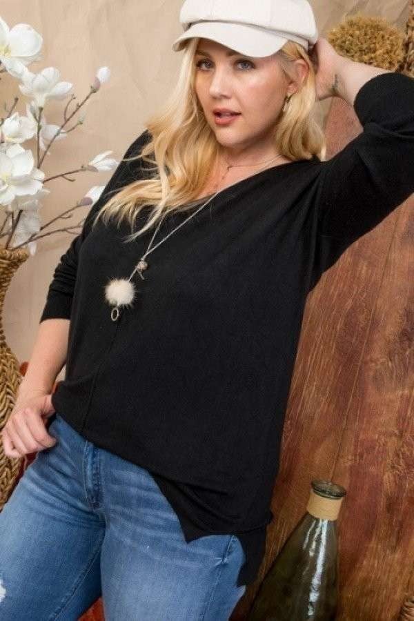 Woman wearing black Plus Size V-Neck Hi-lo Sweater with 3/4 sleeves and side slit, paired with jeans and a white cap.