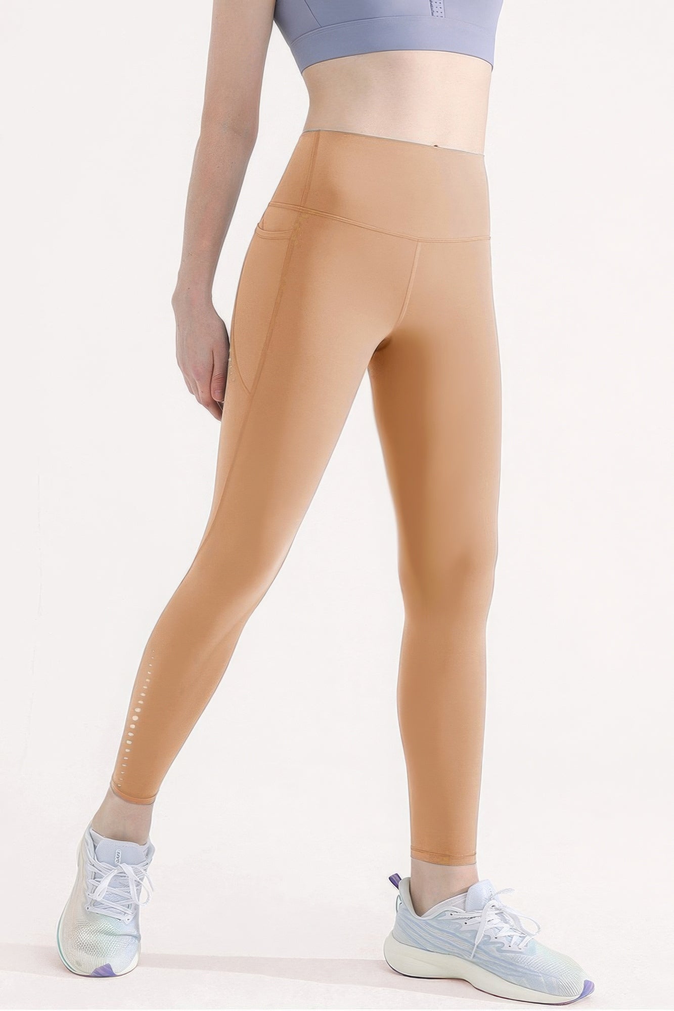 High-waisted yoga leggings with side pocket, reflective dots, and sleek fit in a nude shade, perfect for workouts or casual wear.