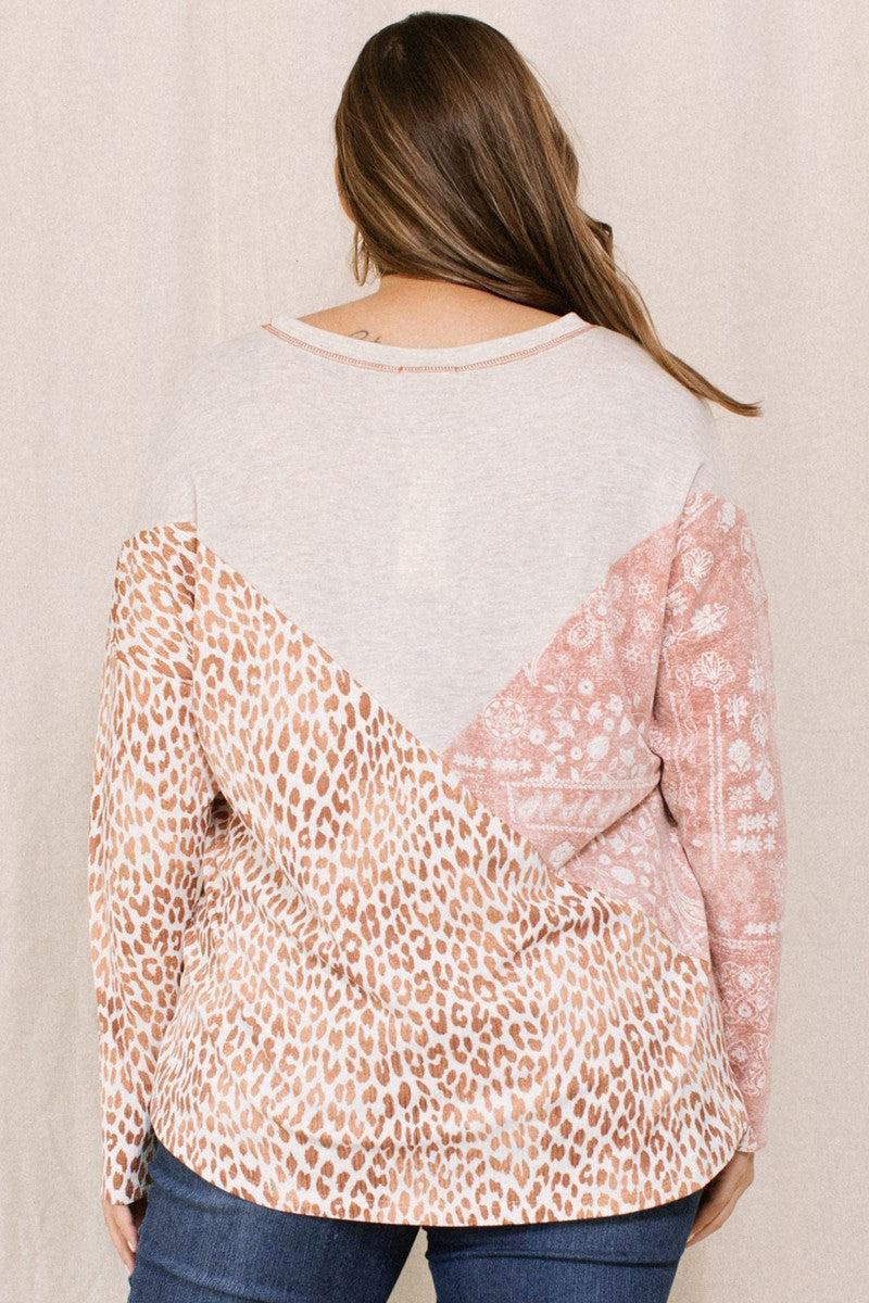 Woman wearing print block French terry top with boat neckline and dolman 3/4 sleeves, featuring brown and pink patterns.