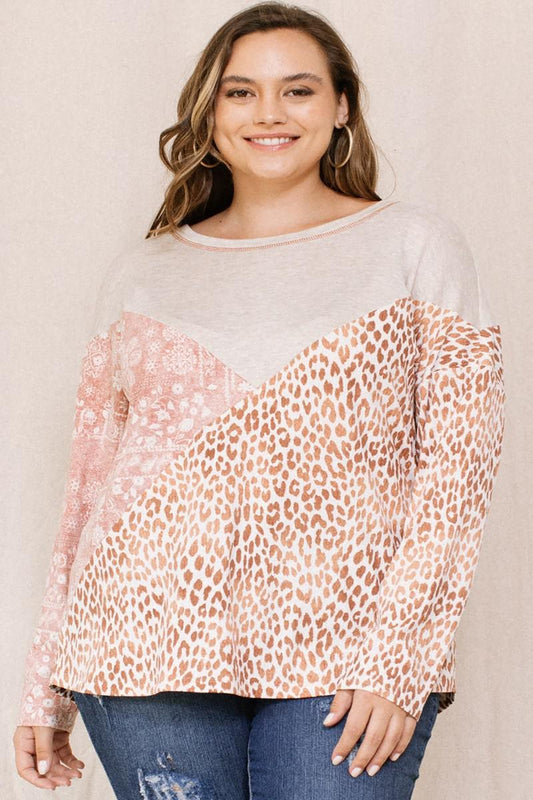 Plus size woman wearing a brown print block French terry top with boat neckline and 3/4 dolman sleeves.