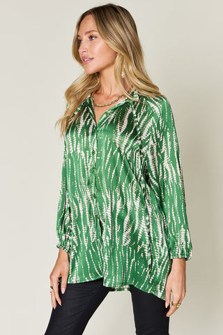 Woman wearing green printed button-up long sleeve shirt with frill detail, made from 100% polyester, no stretch, opaque fabric.