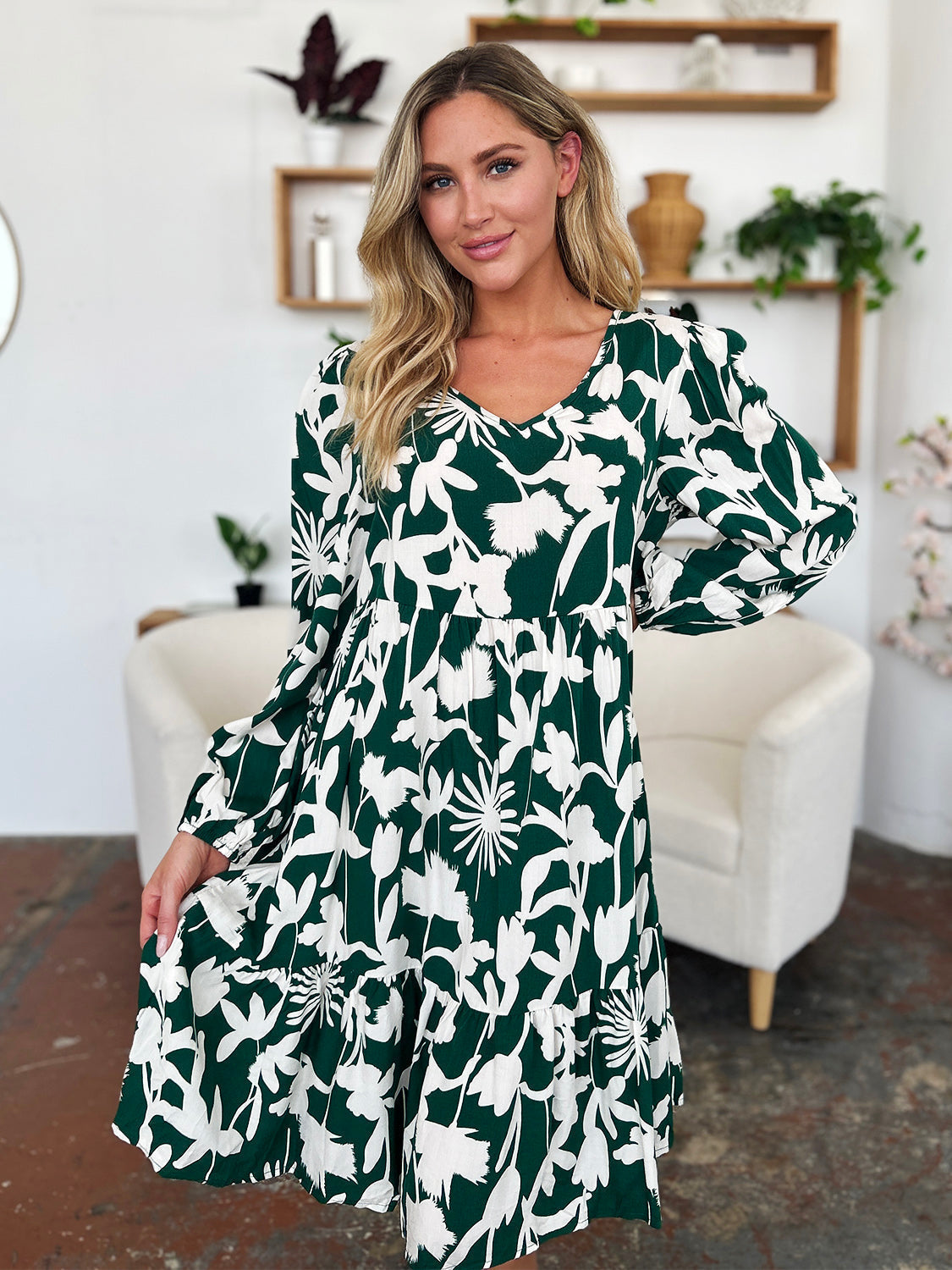 Woman wearing a printed ruffle hem dress with pocket, featuring floral design in green and white, perfect for casual outings.