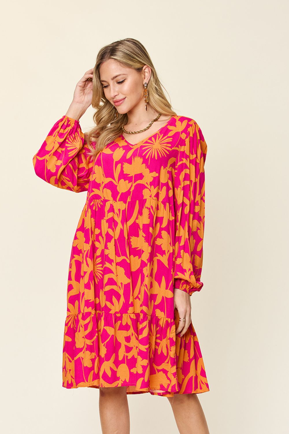 Pink and orange printed ruffle hem dress with long sleeves and pockets, made of 100% rayon.