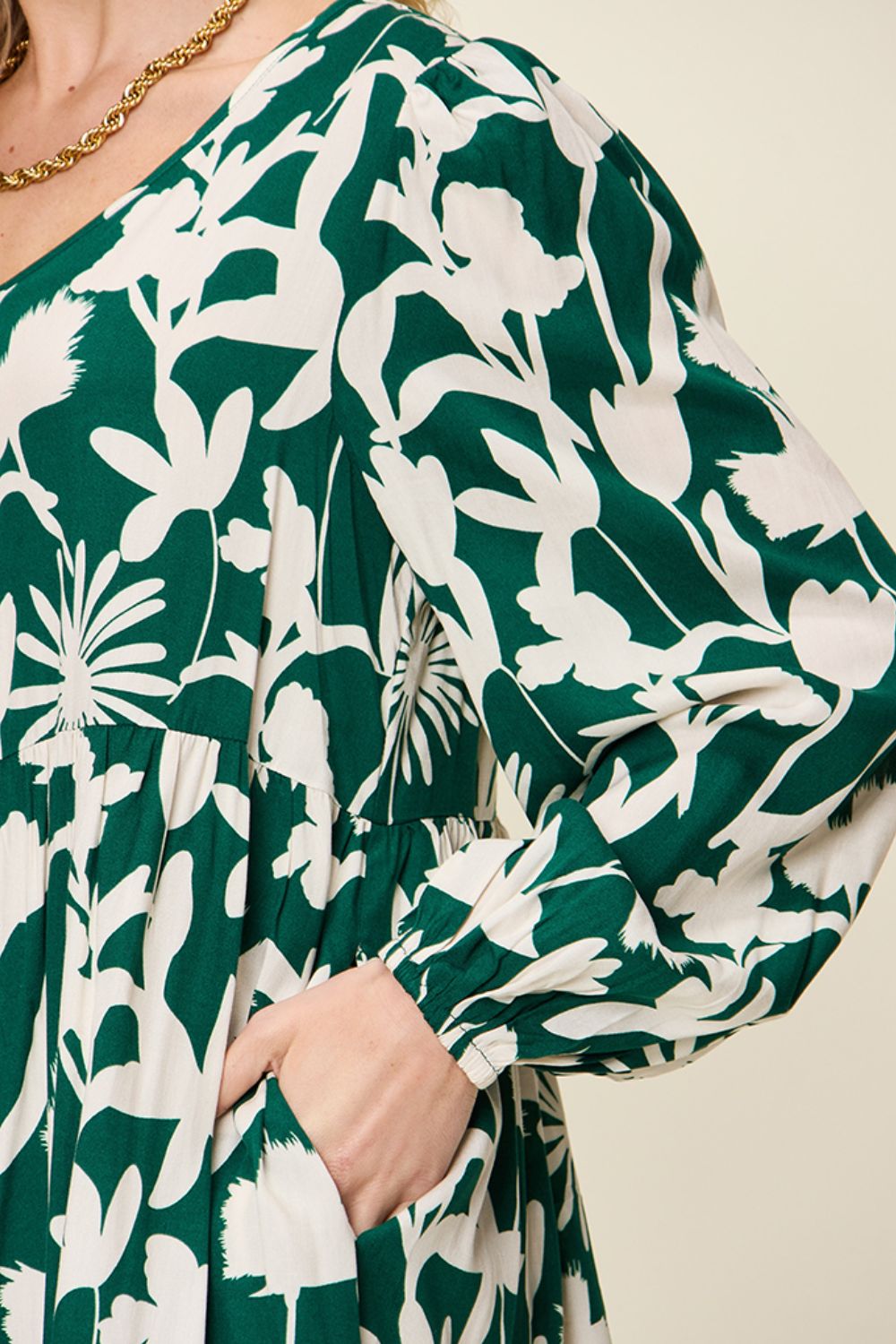 Green printed ruffle hem dress with pocket and floral pattern detailing, featuring long sleeves and a comfortable fit.