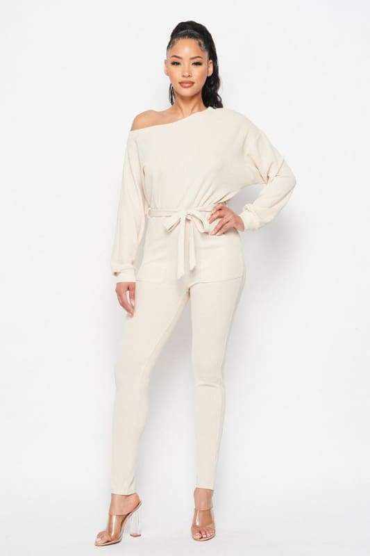 Cream off shoulder waist tie long sleeve jumpsuit made of polyester and spandex.