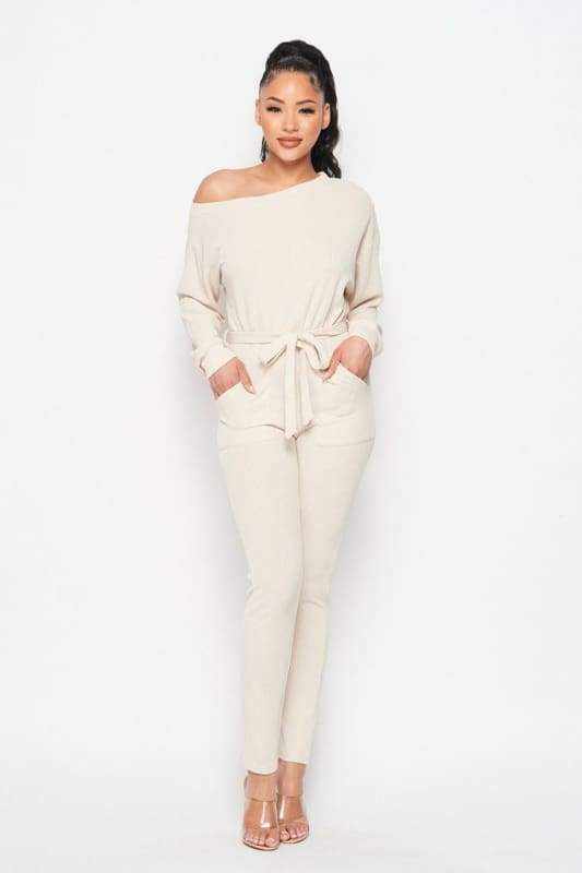 Cream off shoulder waist tie long sleeve jumpsuit made of polyester and spandex, perfect for stylish and comfortable wear.