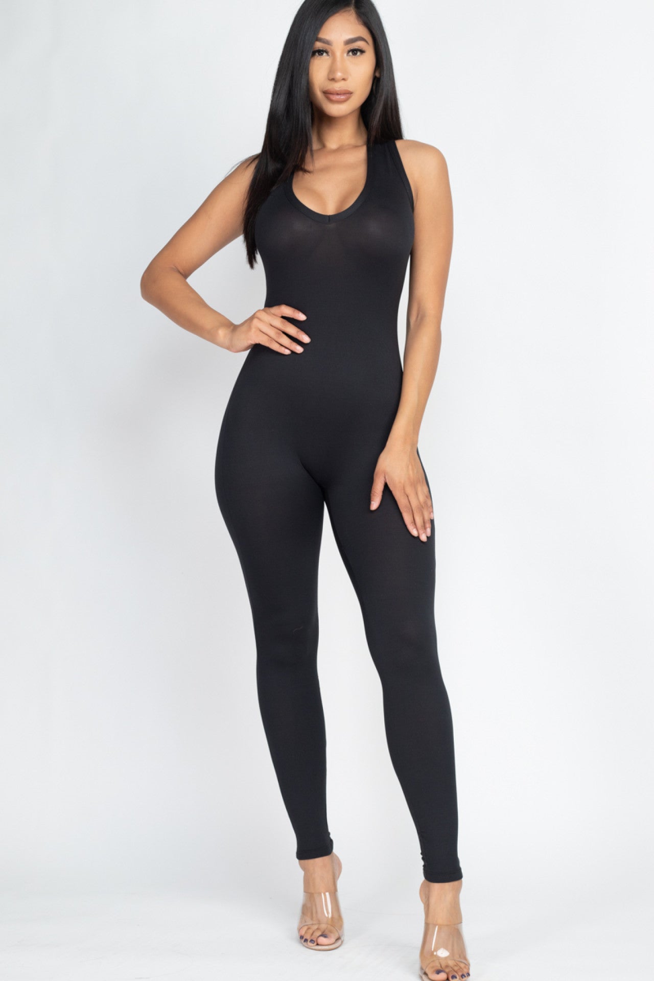 Woman wearing black racer back bodycon jumpsuit, soft and stretchy fabric, perfect for casual and workout wear.