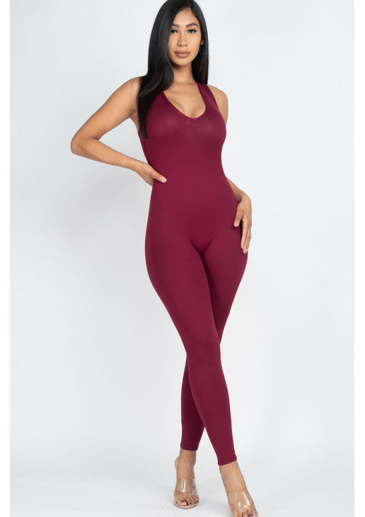 Woman wearing maroon racer back bodycon jumpsuit made of soft, stretchy jersey fabric; suitable for casual or workout wear.