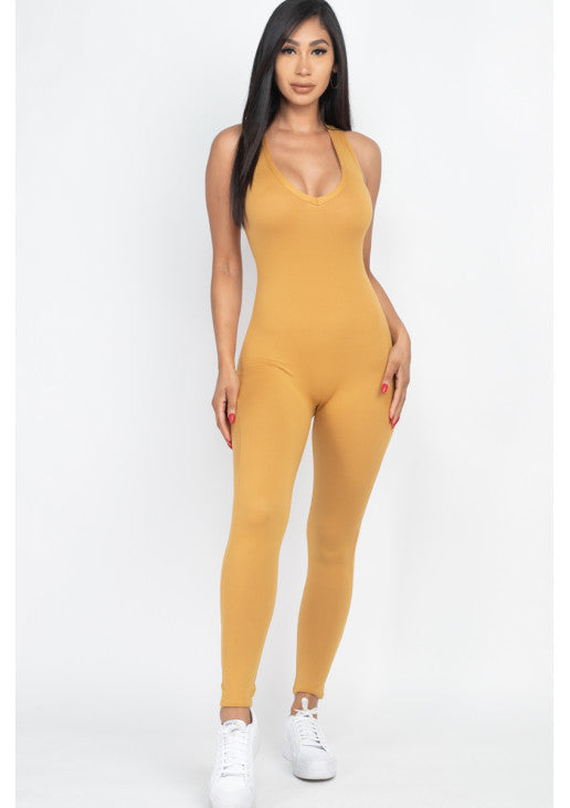 Woman wearing mustard yellow racer back bodycon jumpsuit made of soft, stretchy jersey fabric, perfect for casual and workout wear.