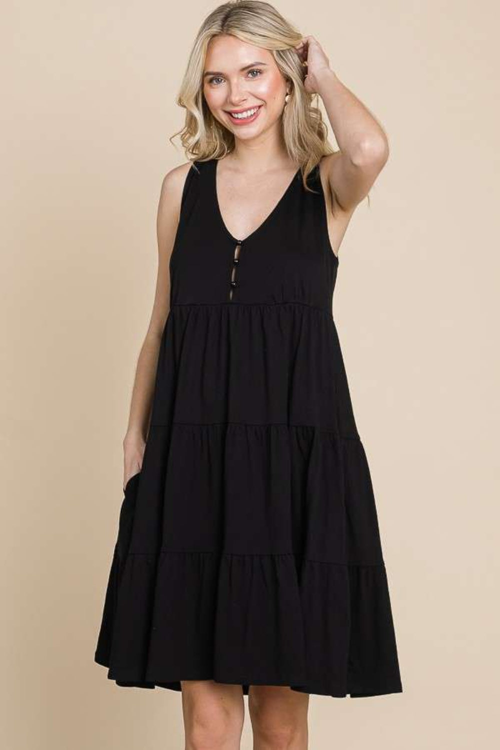 Racerback tiered tank dress in black with ruched detailing, slightly stretchy, made of 60% cotton and 40% rayon.