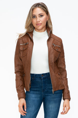 Removable faux layered multi-pocket pleather jacket with fuzzy hood worn by a woman, showcasing its stylish and functional design.