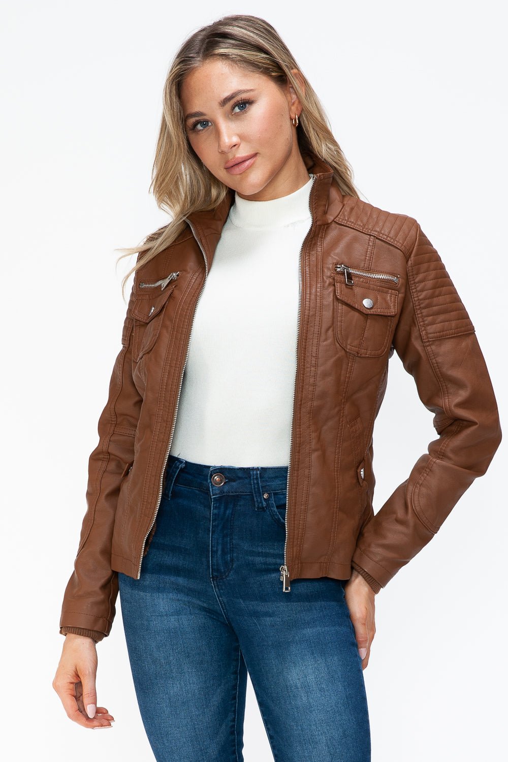 Woman wearing brown removable faux layered multi-pocket jacket with fuzzy hood and pleather material.