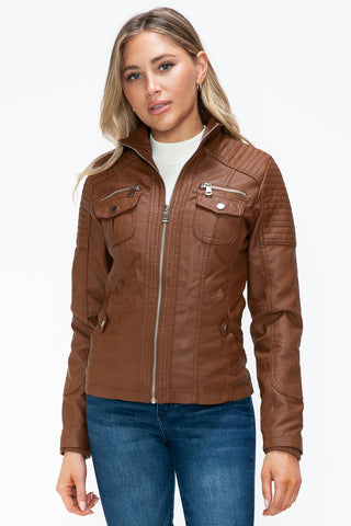 Woman wearing a removable faux layered brown jacket with multiple pockets and a zipper closure, casual style.