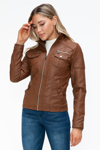 Woman wearing a removable faux layered multi-pocket jacket with a fuzzy hood, showcasing its basic style and pleather material.