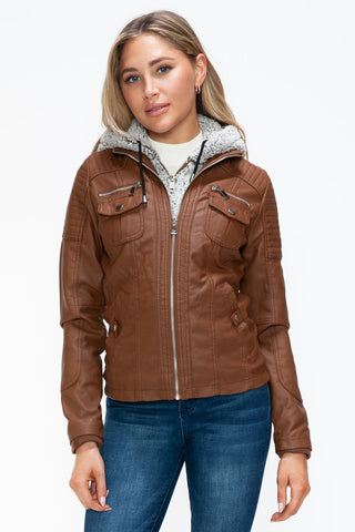 Brown faux leather jacket with removable fuzzy hood and multiple pockets, modeled by a woman wearing jeans.