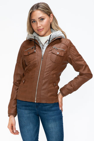 Woman wearing brown faux layered multi-pocket jacket with fuzzy hood and zip-up front.