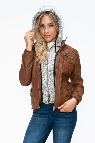 Woman wearing removable faux layered jacket with fuzzy hood, featuring multiple pockets and pleather material.