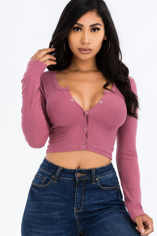 Woman wearing a ribbed long sleeve snap button down crop top in pink, paired with jeans. High stretch knit fabric. Fashion top.