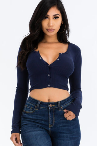 Woman wearing a navy ribbed long sleeve snap button down crop top with high-rise jeans, showcasing the stylish knit fabric and fit.