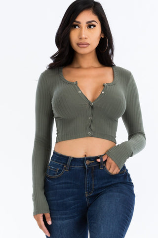 Woman wearing ribbed long sleeve snap button down crop top, olive green with high stretch fabric, paired with blue jeans.