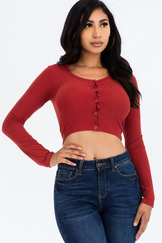 Woman wearing a ribbed long sleeve snap button down crop top in red, made of high stretch rib knit fabric. Fashionable and stylish look.