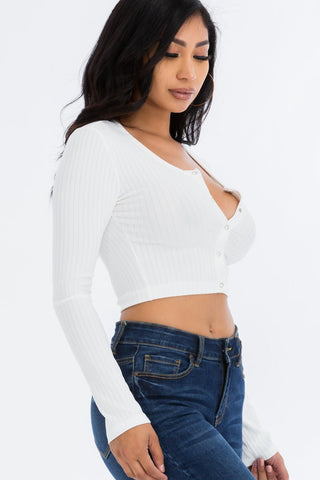 Model wearing ribbed long sleeve snap button down crop top in white. High stretch fabric, 92% polyester, 8% spandex, casual chic style.