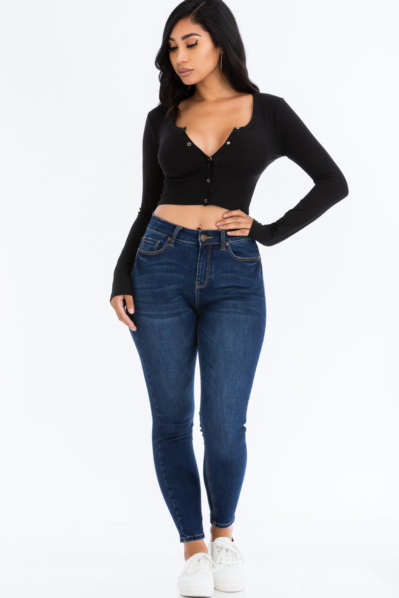 Woman wearing ribbed long sleeve snap button down crop top with jeans and sneakers.