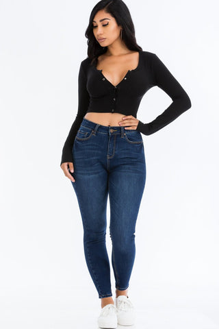 Woman wearing ribbed long sleeve snap button down crop top with jeans and sneakers.