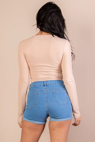 Back view of model in ribbed long sleeve snap button down crop top and denim shorts, showcasing casual chic style and fit.