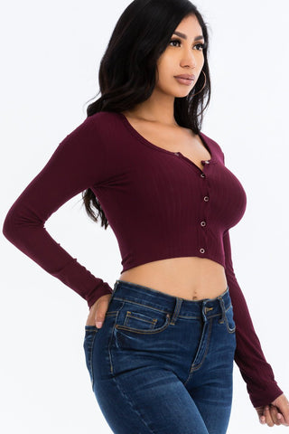 Ribbed long sleeve snap button down crop top in burgundy, worn on a model. High stretch knit with polyester-spandex blend, size small.