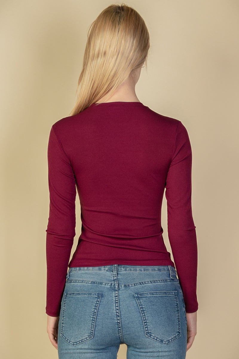 Back view of a model wearing a burgundy ribbed round neck long sleeve top paired with blue jeans.