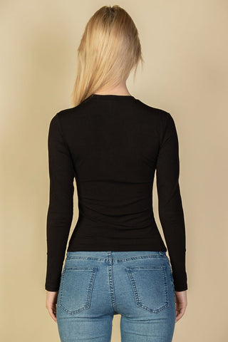 Model wearing a black ribbed round neck long sleeve top with jeans, showcasing the back view. Comfortable, soft stretch fabric.