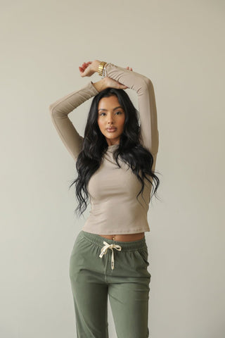 Model wearing a ribbed round neck long sleeve top, showcasing the soft stretch rib knit material in a casual pose.