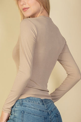 Ribbed round neck long sleeve top in beige, featuring soft stretch fabric, worn by model. Polyester and spandex blend.