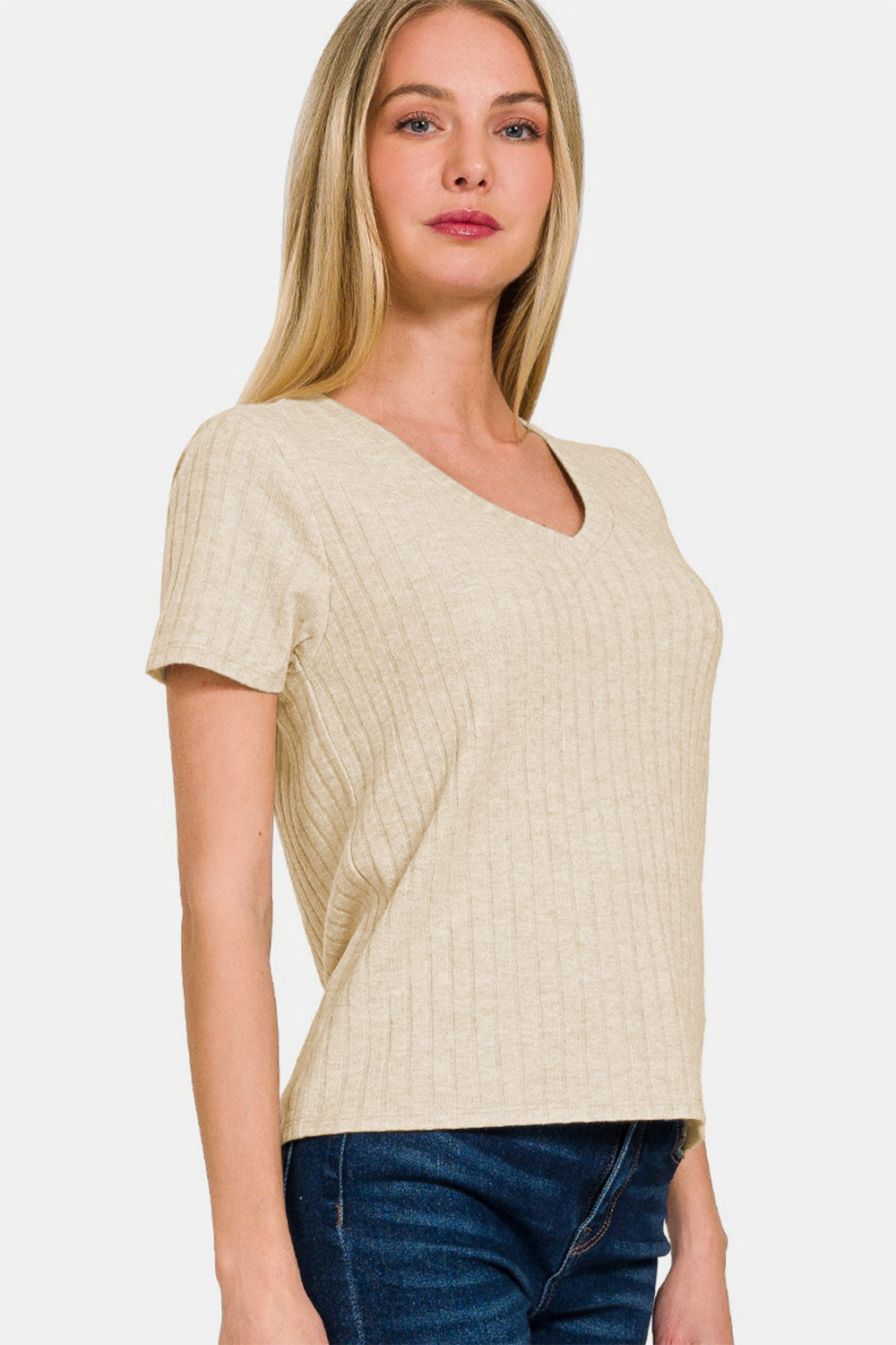 Woman wearing ribbed short sleeve t-shirt, beige color, no stretch, rayon blend, paired with blue jeans.