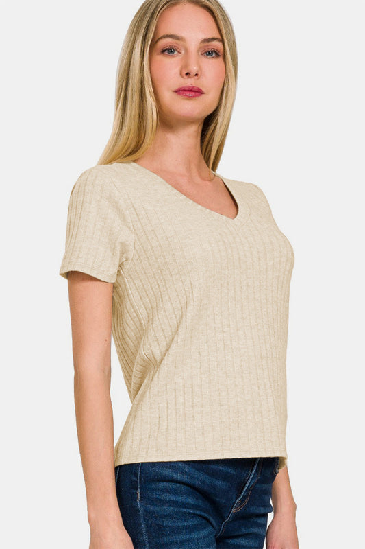 Woman wearing ribbed short sleeve t-shirt, beige color, no stretch, rayon blend, paired with blue jeans.